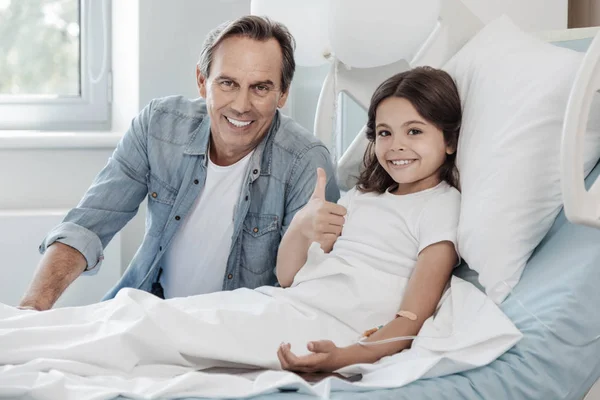 Nadenkende man vising zijn dappere lachende dochter in het ziekenhuis — Stockfoto