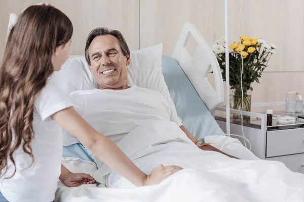 Hombre extremadamente feliz sonriendo mientras mira a su hija en el hospital — Foto de Stock