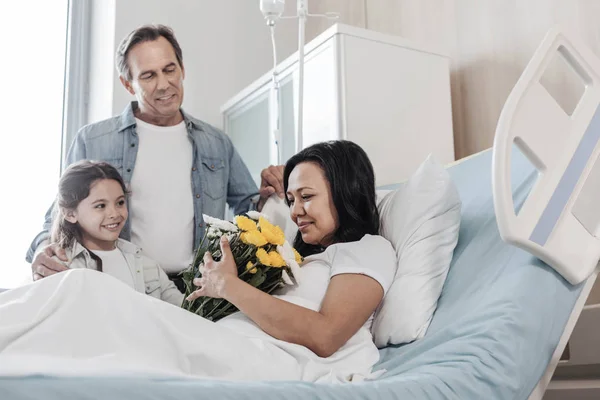 Выборочный акцент на счастливую женщину, получающую поддержку семьи в больнице — стоковое фото