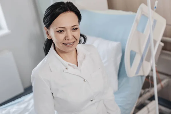 Fundersam kvinnlig medicinsk arbetare ler glatt på sjukhus — Stockfoto