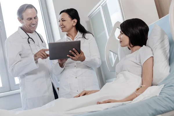 Zufriedene medizinische Mitarbeiter lächeln im Gespräch mit Patientinnen — Stockfoto