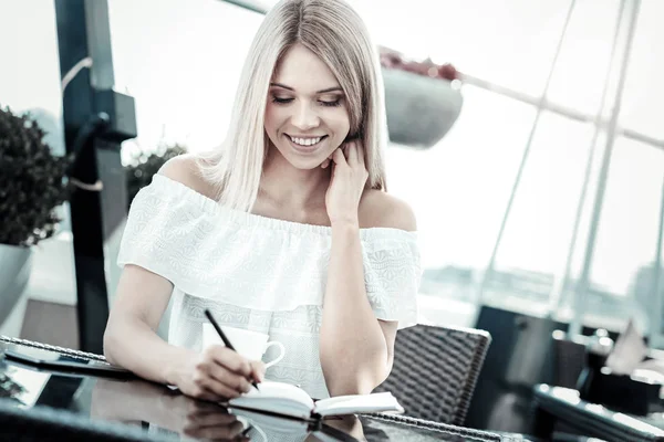 Nice positive businesswoman taking notes — Stock Photo, Image