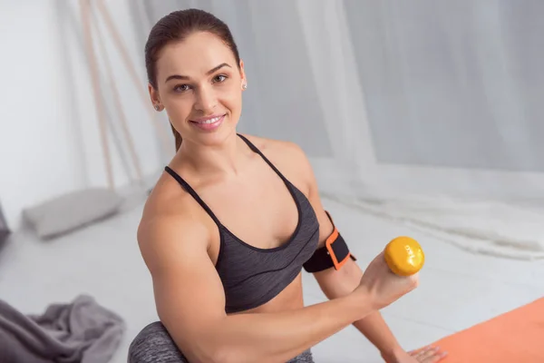 Mujer sonriente haciendo ejercicios con pesas en casa —  Fotos de Stock