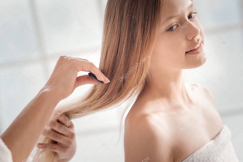 Nice beautiful girl having her hair combed