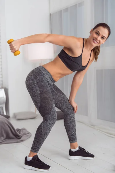 Happy woman using hand weights while exercising