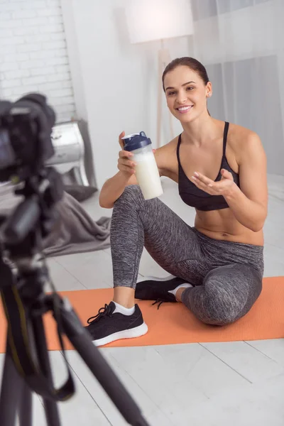 Vrolijke gespierde blogger houdt van een drankje voor de camera — Stockfoto