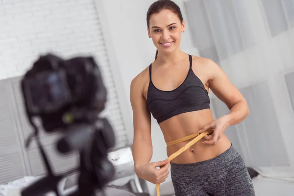 Aufmerksame junge Frau misst ihre Taille — Stockfoto