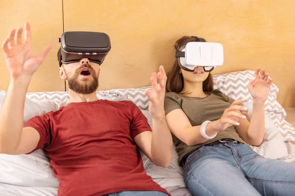 Entusiasta pareja sorprendida viviendo aventura en VR — Foto de Stock