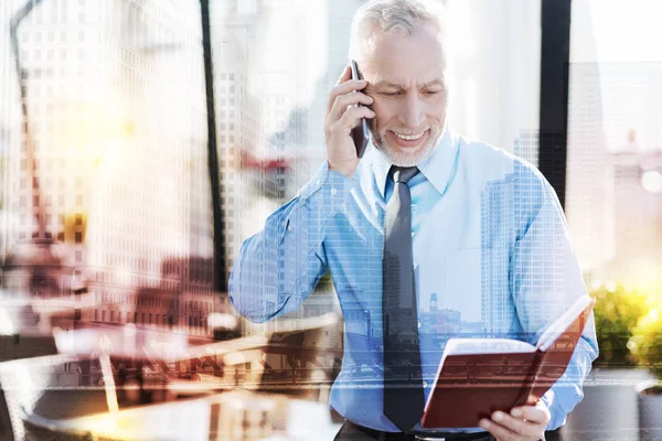 Vertrouwen rijpe zakenman notities lezen en praten over de telefoon — Stockfoto