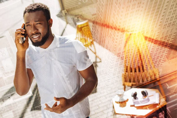 Hombre preocupado mirando al cielo y teniendo una charla telefónica desagradable — Foto de Stock