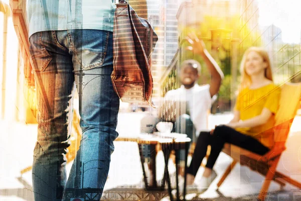 Junges Paar entspannt sich in einem Café und bemerkt seinen Freund — Stockfoto