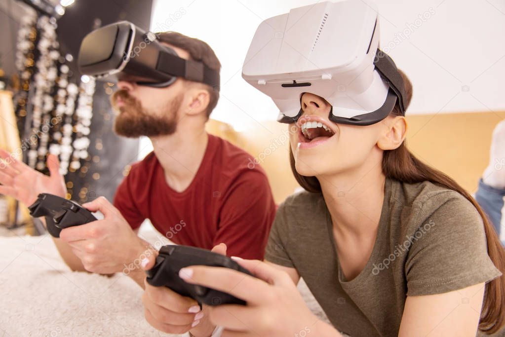 Emotional happy couple passing game in VR glasses