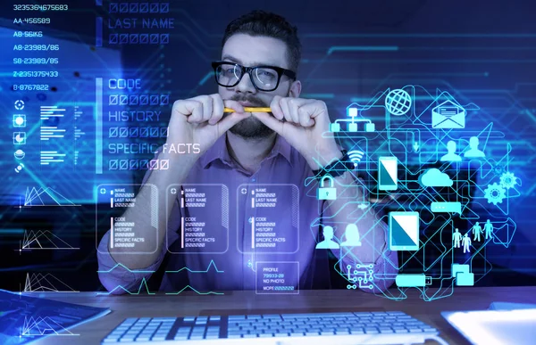 Attentive thoughtful programmer biting his pencil while sitting alone — Stock Photo, Image