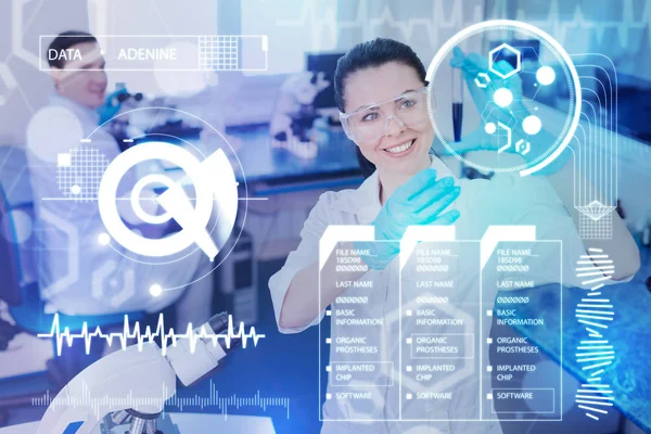 Médico sonriente mirando la muestra después de probarla en un laboratorio moderno — Foto de Stock