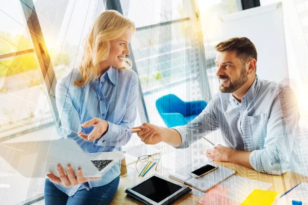 Vriendelijke medewerkers kijken naar elkaar en vriendelijk glimlachend — Stockfoto