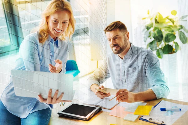 Mujer positiva señalando a la pantalla de su portátil y sonriendo — Foto de Stock