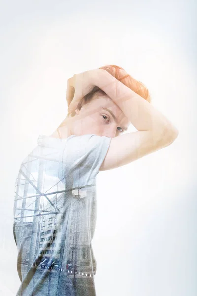Knappe jongeman verbergen van zijn gezicht terwijl permanent zijwaarts — Stockfoto