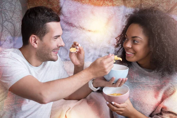 Feliz casal positivo alimentando uns aos outros — Fotografia de Stock