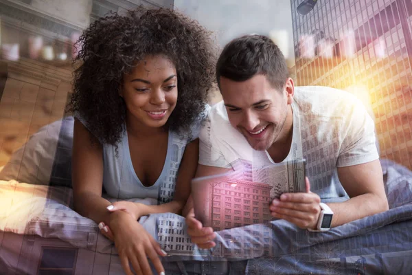 Alegre pareja positiva mirando la pantalla de la tableta —  Fotos de Stock