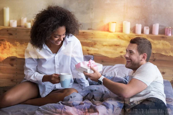 Encantado homem positivo dando um presente para sua namorada — Fotografia de Stock