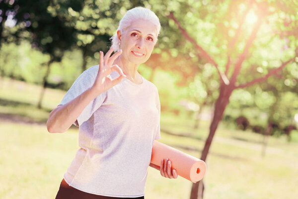 Waist up of cheerful elderly woman being outdoors