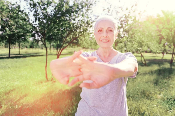 Midja upp av äldre kvinna att hålla händerna framåt — Stockfoto