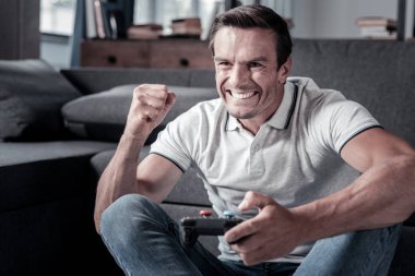 Heyecanlı adam video oyunları oynarken başarı kutluyor