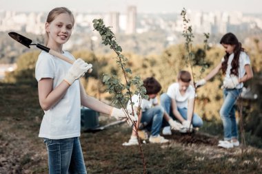 Bir kürek tutan şirin gülen kız
