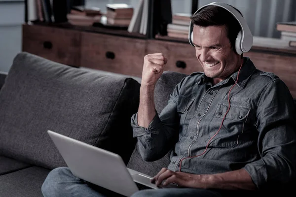 Zufriedener Mann feiert Erfolg bei der Arbeit am Laptop — Stockfoto