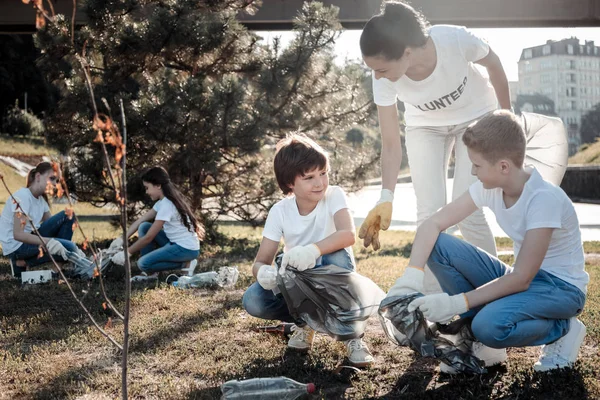 Mujer joven agradable hablando con los niños — Foto de Stock