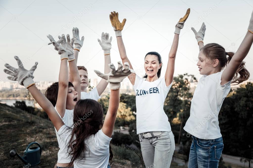 Happy joyful team raising their hands