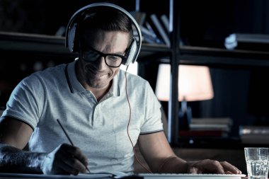 Müzik dinlerken not alma parlak olgun adam