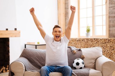 Evde futbol izlerken mutlu genç