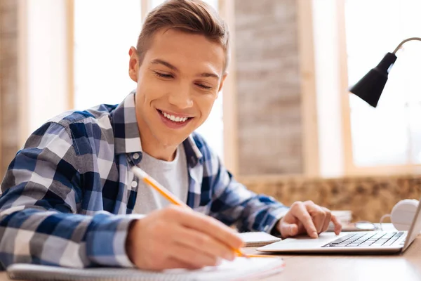 Adolescent joyeux apprenant ses leçons à la maison — Photo