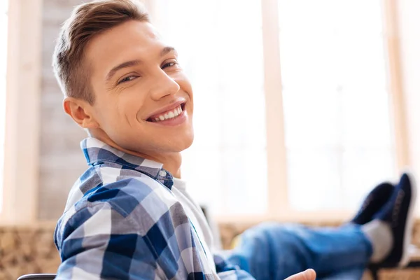 Glædelig ung mand afslappende og smilende - Stock-foto