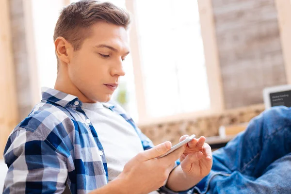 Adolescente serio y no sonriente usando su teléfono — Foto de Stock