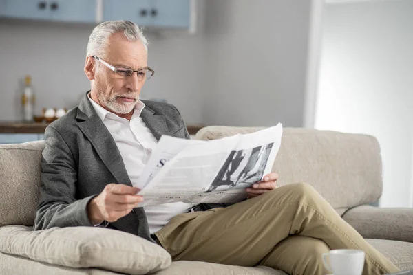 Hombre guapo leyendo interesante artículo —  Fotos de Stock