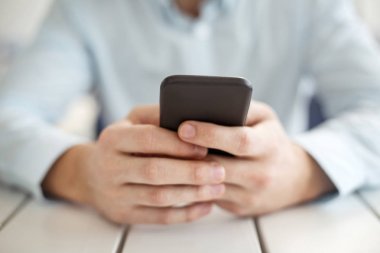 Düzgün adam modern bir telefonda yazarak