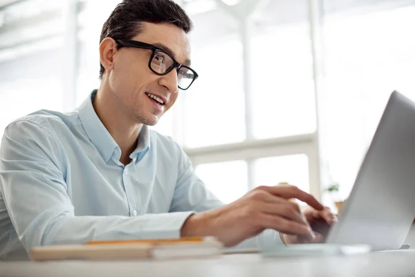 Hombre de negocios sonriente trabajando en su portátil — Foto de Stock