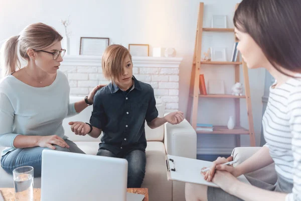 Känslomässiga pojke gestikulerande fördriva tiden talande till kvinnliga psykoterapeut — Stockfoto