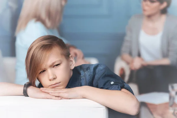 Chagrijnig kind ontspannen op de sofa in psycholoog kantoor — Stockfoto