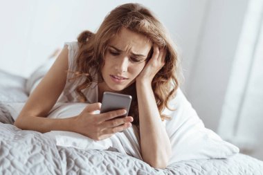 Duygusal olarak yorgun kadın onun smartphone kullanırken yapması