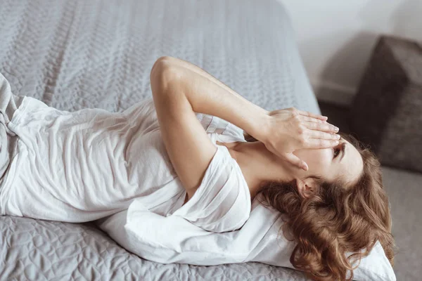 Emotionally exhausted woman crying on bed — Stock Photo, Image