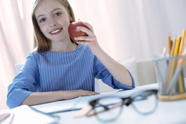Responsible pupil holding a tasty apple — Stock Photo, Image