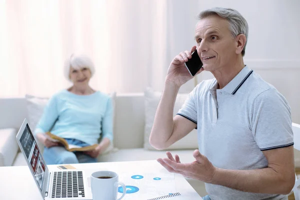 Positive senior man talking on the phone and smiling — Stock Photo, Image