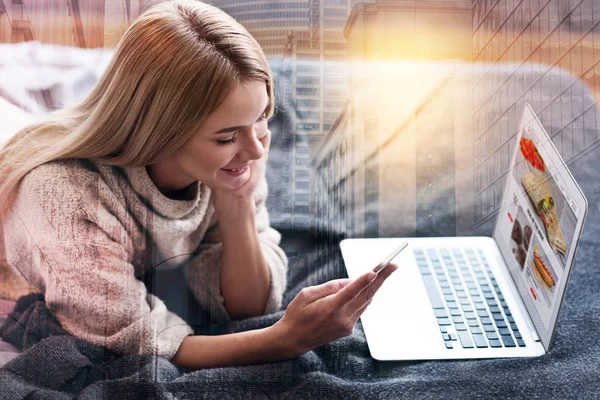 Mujer alegre agradable mirando la pantalla de su teléfono inteligente — Foto de Stock