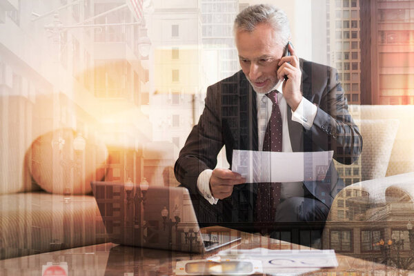 Smiling successful man talking on phone with business partner