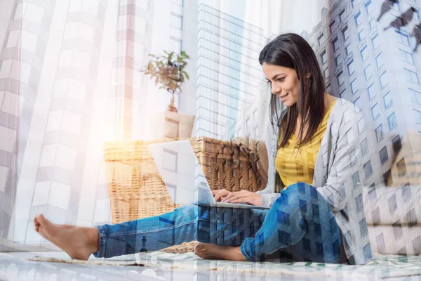 Lächelnde schöne Frau, die zu Hause an ihrem Laptop arbeitet — Stockfoto