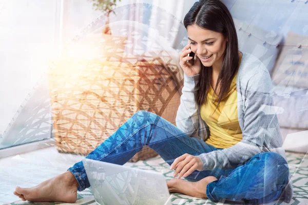 Дружня молода жінка розмовляє по телефону, сидячи вдома — стокове фото
