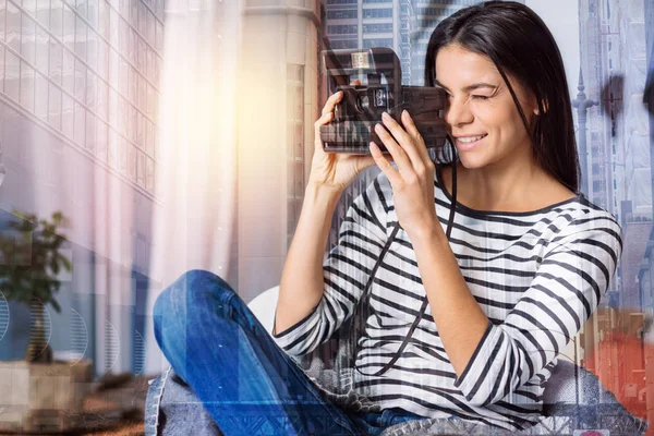 Härlig ung kvinna som innehar ett ögonblick fotokamera — Stockfoto